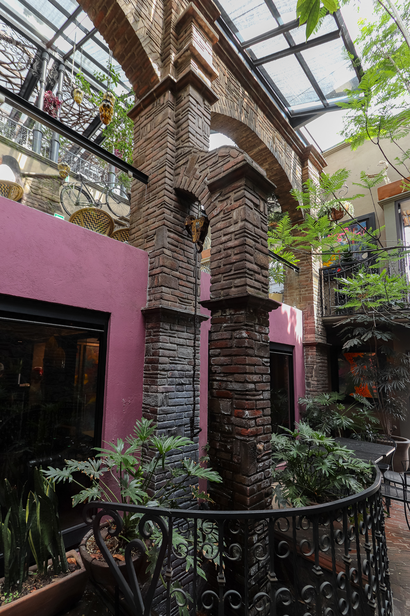Columnas y arcos de ladrillo con muro magenta