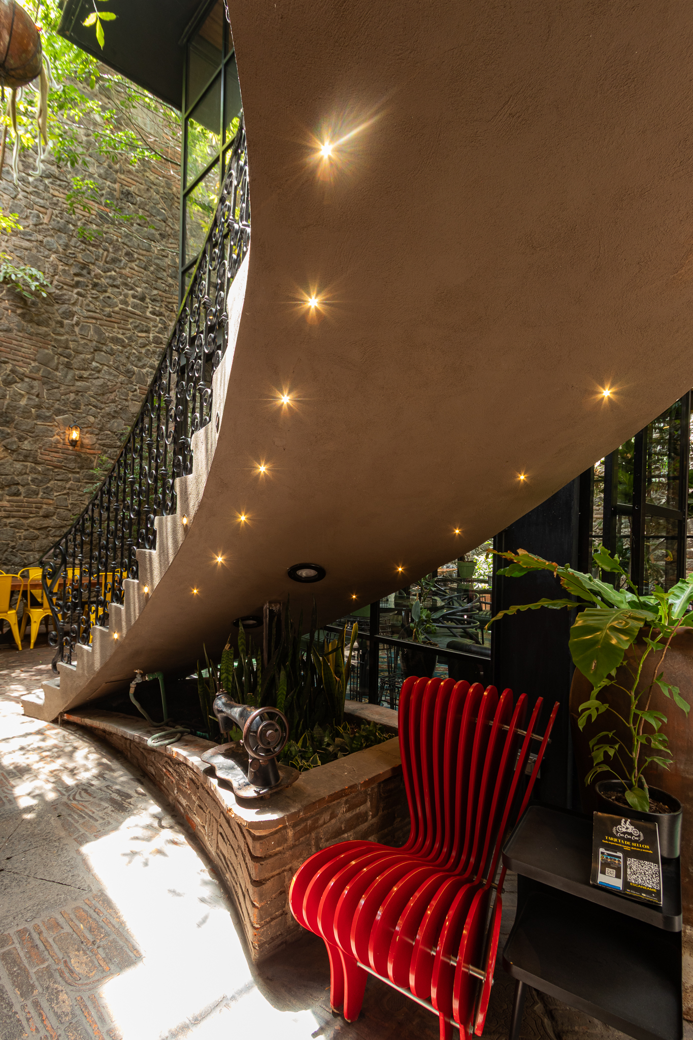 Escalera escultórica iluminada y silla roja