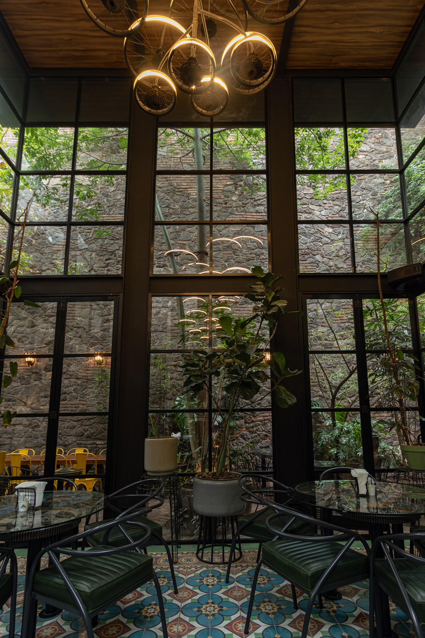 Cus Cus Cus Santuario — ventanales y patio de piedra